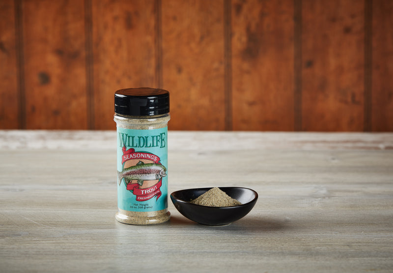 Wildlife Seasonings Trout Freshwater Blend 7.0 oz. bottle beside a small bowl of the seasoning on a rustic wood table