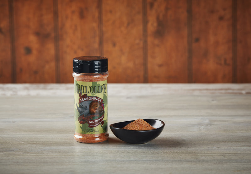 Wildlife Seasonings All Purpose Southern Blend 6.5 oz. bottle beside a small bowl of the seasoning on a rustic wood table